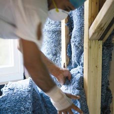man installing recycled denim insulation batts