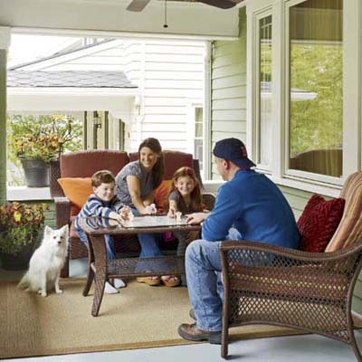homeowners and their two kids and dog on the front porch of a newly remodeled foursquare