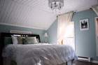 bedroom with white sloped ceiling and blue walls