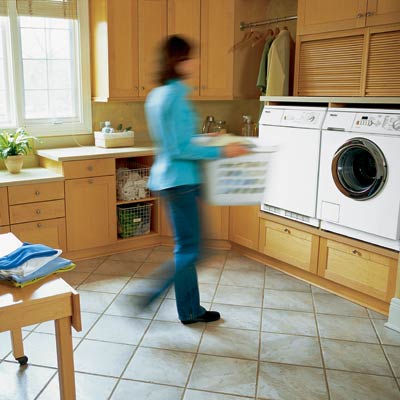 woman carrying laundry basket in laundry room