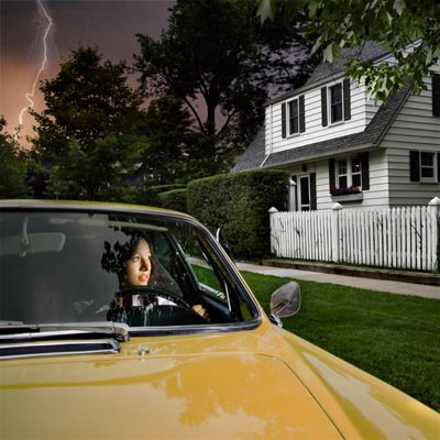 woman driving away from ominous house