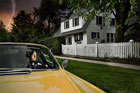 woman driving away from ominous house