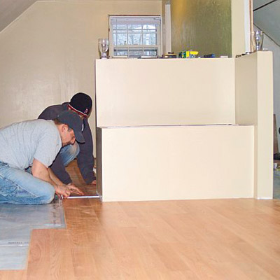 men working on installing built in storage bench in remodeled attic