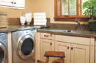laundry room set up in garage with slated walls for storage