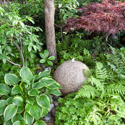 granite sphere fountain, ferns, hostas 