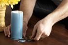 person using gift card to scrape wax that dripped onto a wooden table
