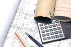 ruler, calculator, building plans on a table