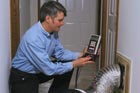 a man using a digital temperature gauge to test a duct system