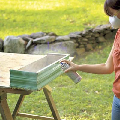 woman sealing window box finish