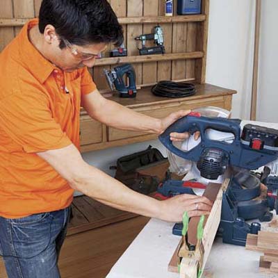 Mark Powers uses a miter saw to cut pieces for a bar cart