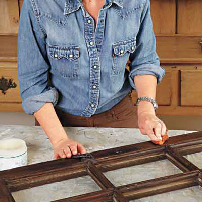 woman prepares salvaged window sash