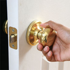 hand pulling a door by the knob