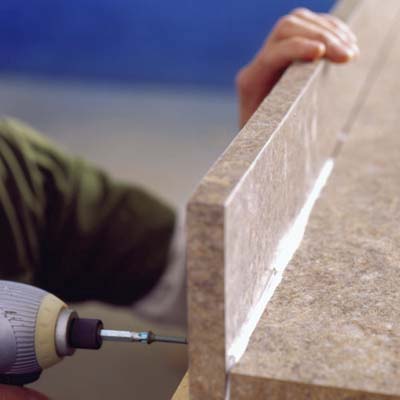  Drive screws through the pilot holes to secure the backsplash