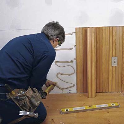 Tom Silva applying an adhesive before wainscoting 