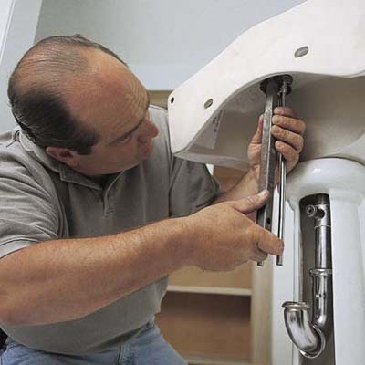 Richard Trethewey connecting the drain of a pedestal sink