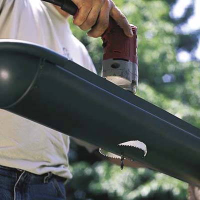 cutting downspout holes in a gutter