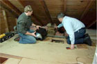 this old house host kevin o'connor in an attic watching installation of a bathroom fan for the floor below