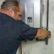 richard trethewey standing before a newly installed propane tankless water heater
