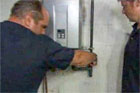 richard trethewey standing before a newly installed propane tankless water heater