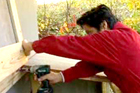 man installs cover for new trash storage shed