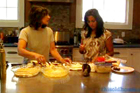 2 women prepping food on a kitchen island