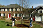 Roger Cook and homeowner plant a fully grown tree in the middle of a spacious yard
