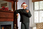 This Old House editor, Scott Omelianuk with a Santa hat and tossing a xmas ball in the air while leaning on the mantel