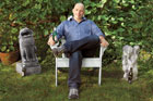 TOH editor Scott Omelianuk sits in his back yard with a beer between two stone gargoyles