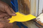 spreading epoxy on window trim to fix rotting wood on an exterior window