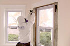 removing lead from around a window frame with full Hazmat suit