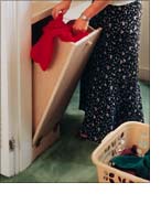 The laundry chute door, made of plywood, is attached with two hinges and a loop chain.