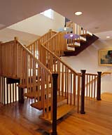 Windows in the stairwell bring light into the center of the house. The stairway itself is the centerpiece of the remodeled first floor. It consists of wood treads that are supported by a red steel stringers. 