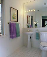 On the second floor, each of the girls has a full bath to herself. Concealed push latches on the medicine cabinet keep the expanse of mirror free of hardware.
