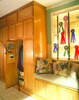 A hard-working window seat is assembled from short cupboard units. The top row of cabinetry is made up of regular wall units installed sideways so their doors open upward and out of the way.