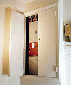 door conceals electrical panel in finished basement