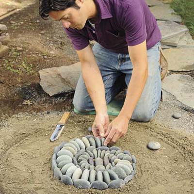 Mark Powers filling in the spiral pattern in his pebble mosaic